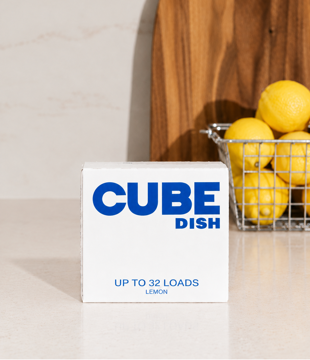 CUBE Dish Lemon dishwasher detergent cubes, up to 32 loads, next to a basket of lemons